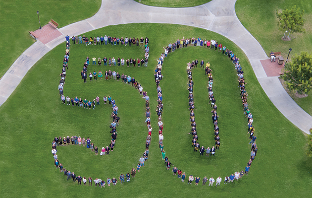 group standing in shape of 50